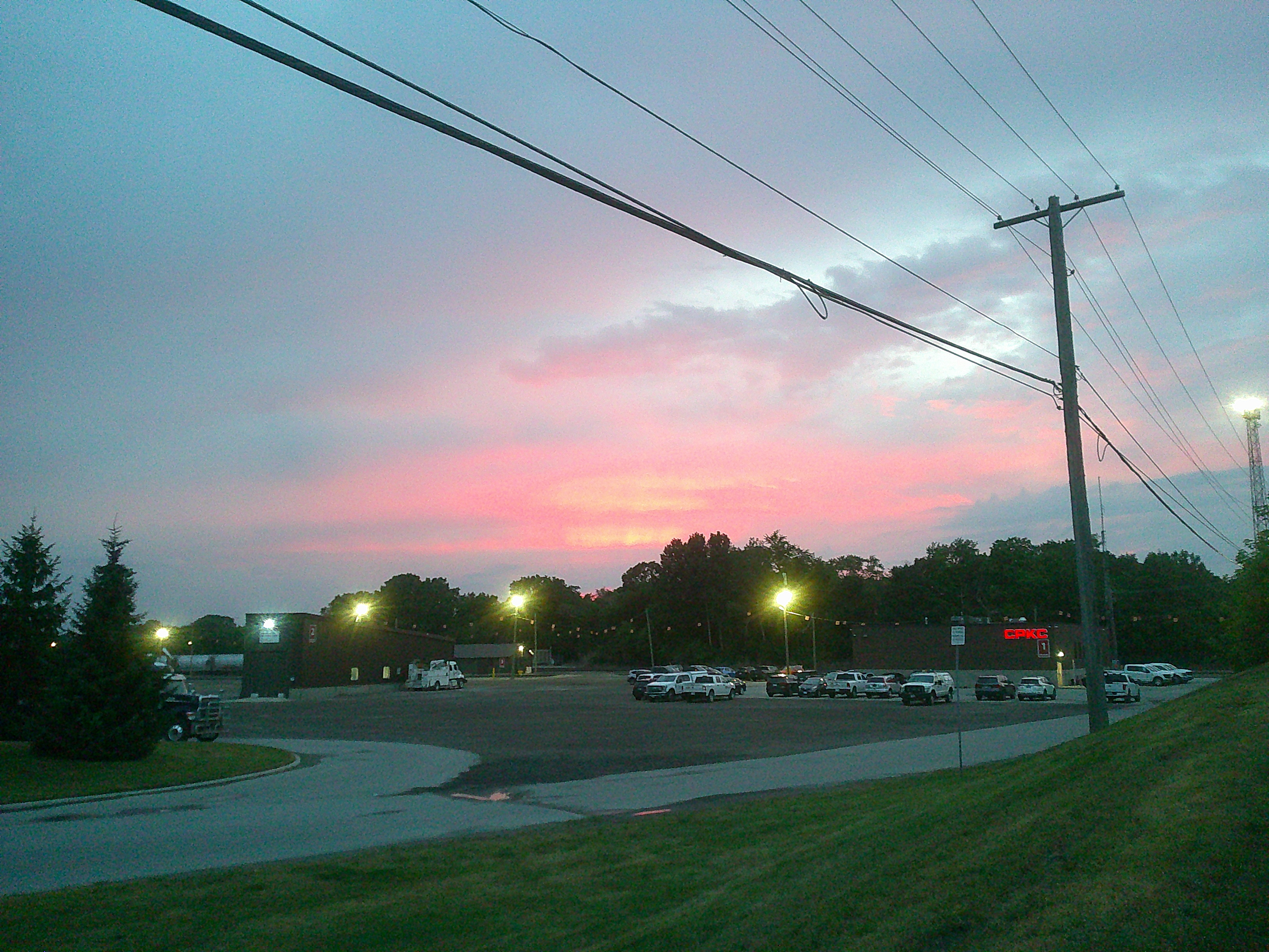 A picture of a beautiful sunset over a train yard.